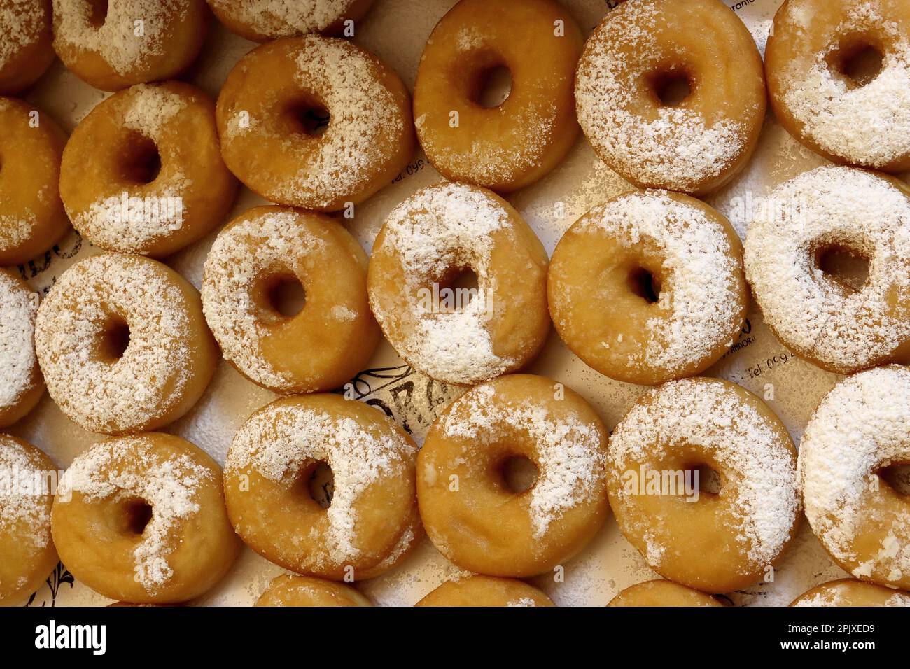 Confezione di ciambelle fritte con zucchero a velo Foto Stock