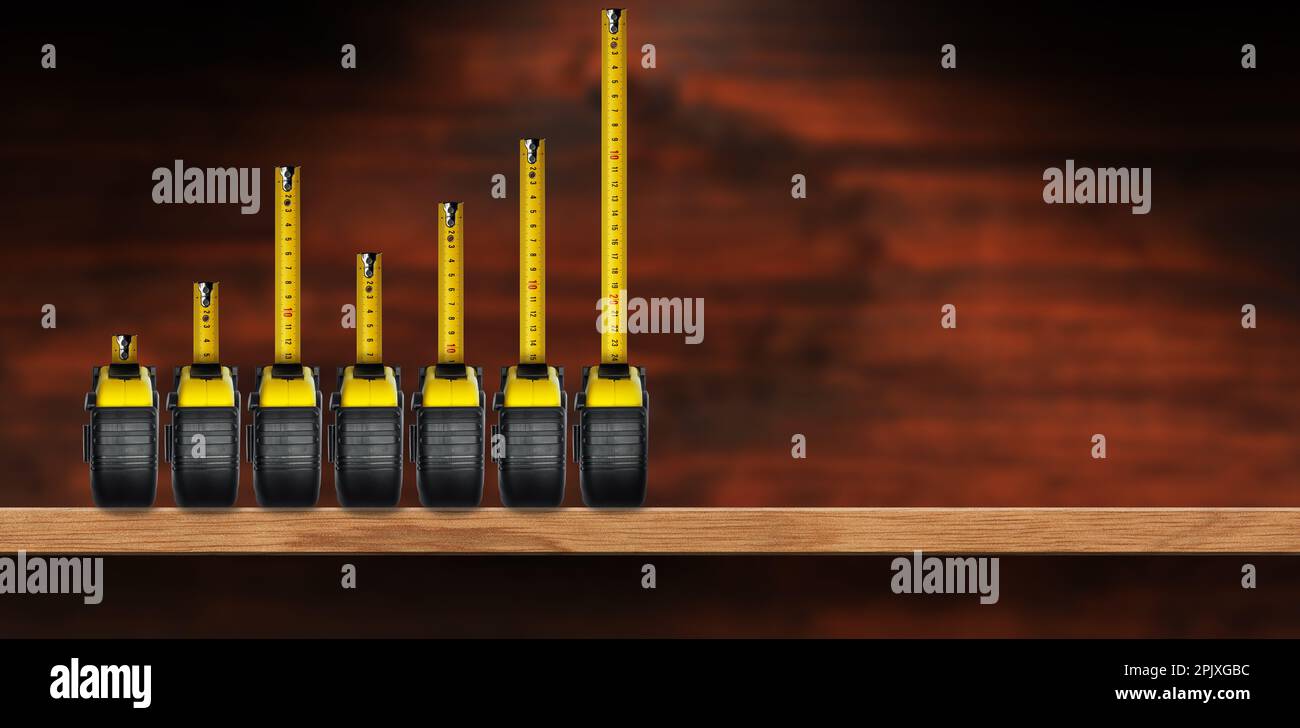 Gruppo di sette misure nastro formando un grafico a barre, su una mensola di legno con spazio copia, interno casa. Foto Stock