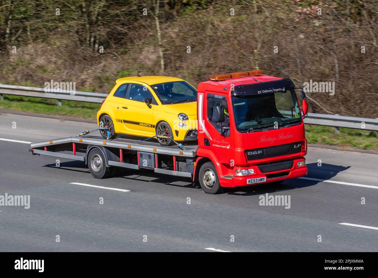 Trasportatori storici, esperti di consegna auto EV  Red DAF fa LF45.180 furgone da 5880 cc 45,170 GIORNI con 2017 FIAT ABARTH 1368 cc benzina manuale a 5 velocità; viaggia a velocità sostenuta sull'autostrada M6 a Greater Manchester, Regno Unito Foto Stock