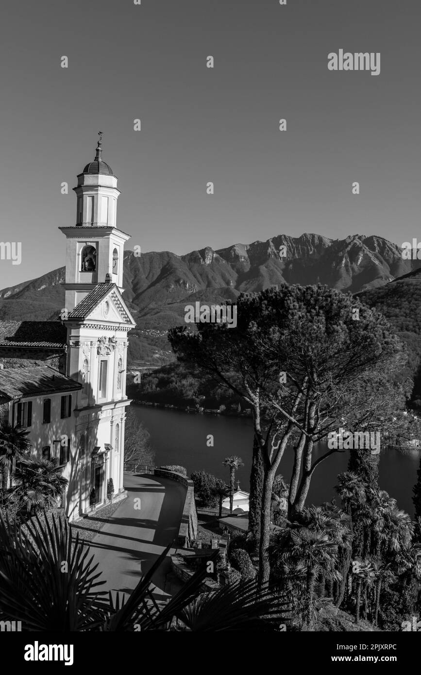 Chiesa dei Santi fedele e Simone e Lago di Lugano con montagna in una giornata di sole a Vico Morcote, Ticino in Svizzera. Foto Stock