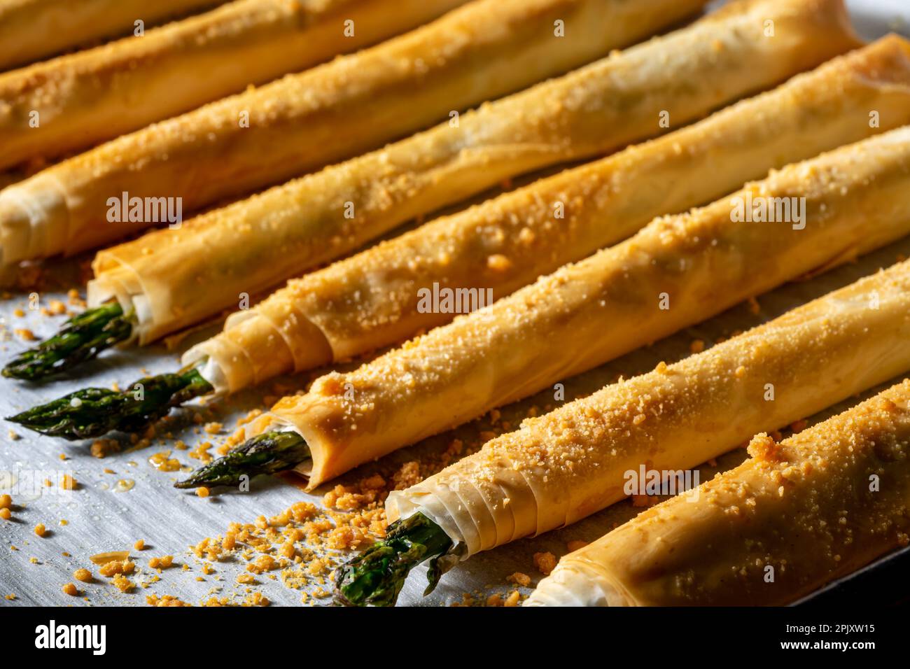 Asparagi avvolti in pasta di phylo e cotti al forno. Primo piano, sopra lo scatto. Foto Stock