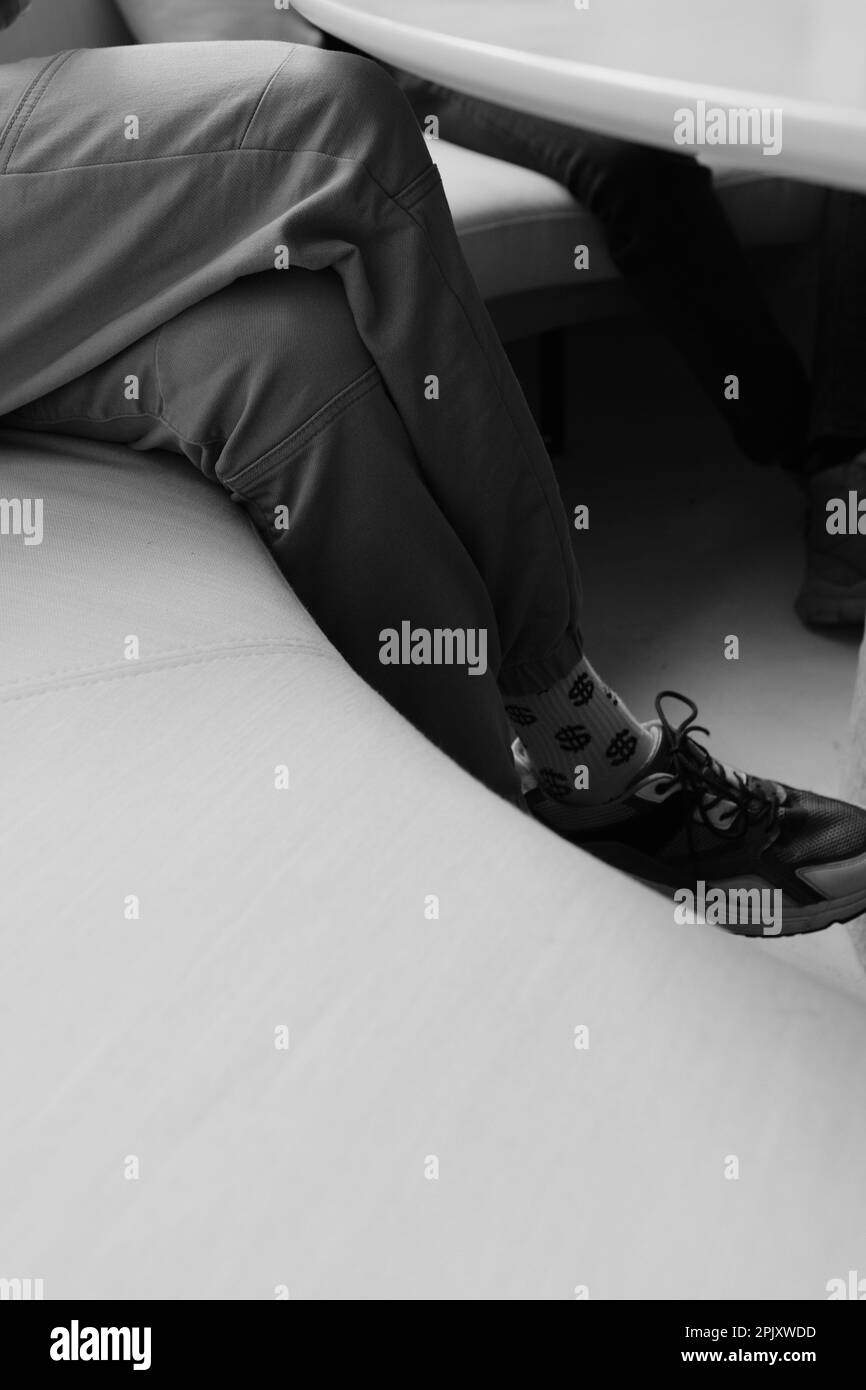 paio di gambe in calze con un motivo dollaro, foto in bianco e nero dell'uomo moderno in pantaloni scarpe e sokes con dollar patern Foto Stock