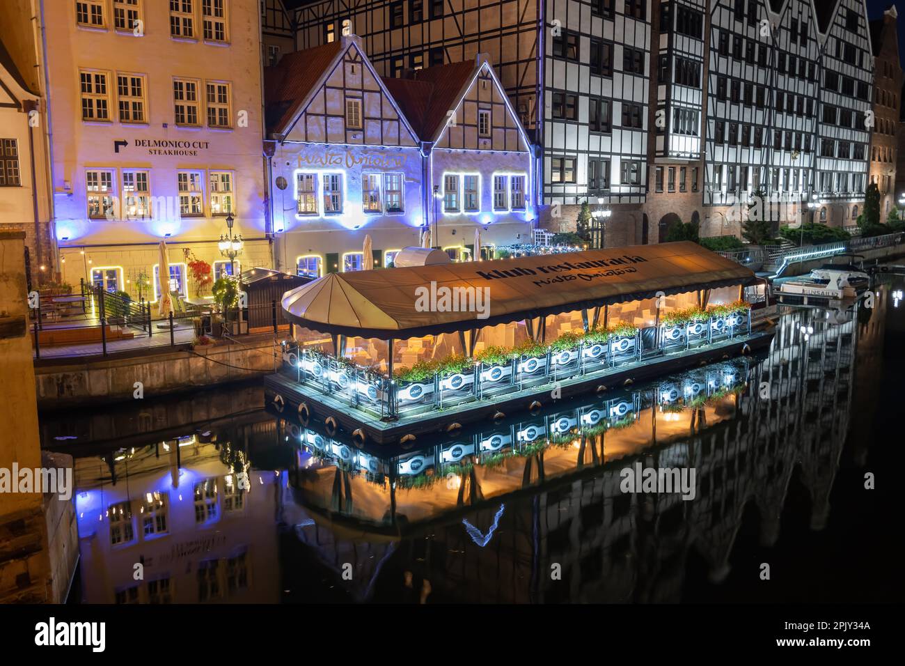 Città di Gdańsk, Polonia - 9 ottobre 2022 - Granary Island bellissimo lungofiume di notte con il ristorante Club Città degli Angeli (polacco: Miasto Aniołów) a Foto Stock