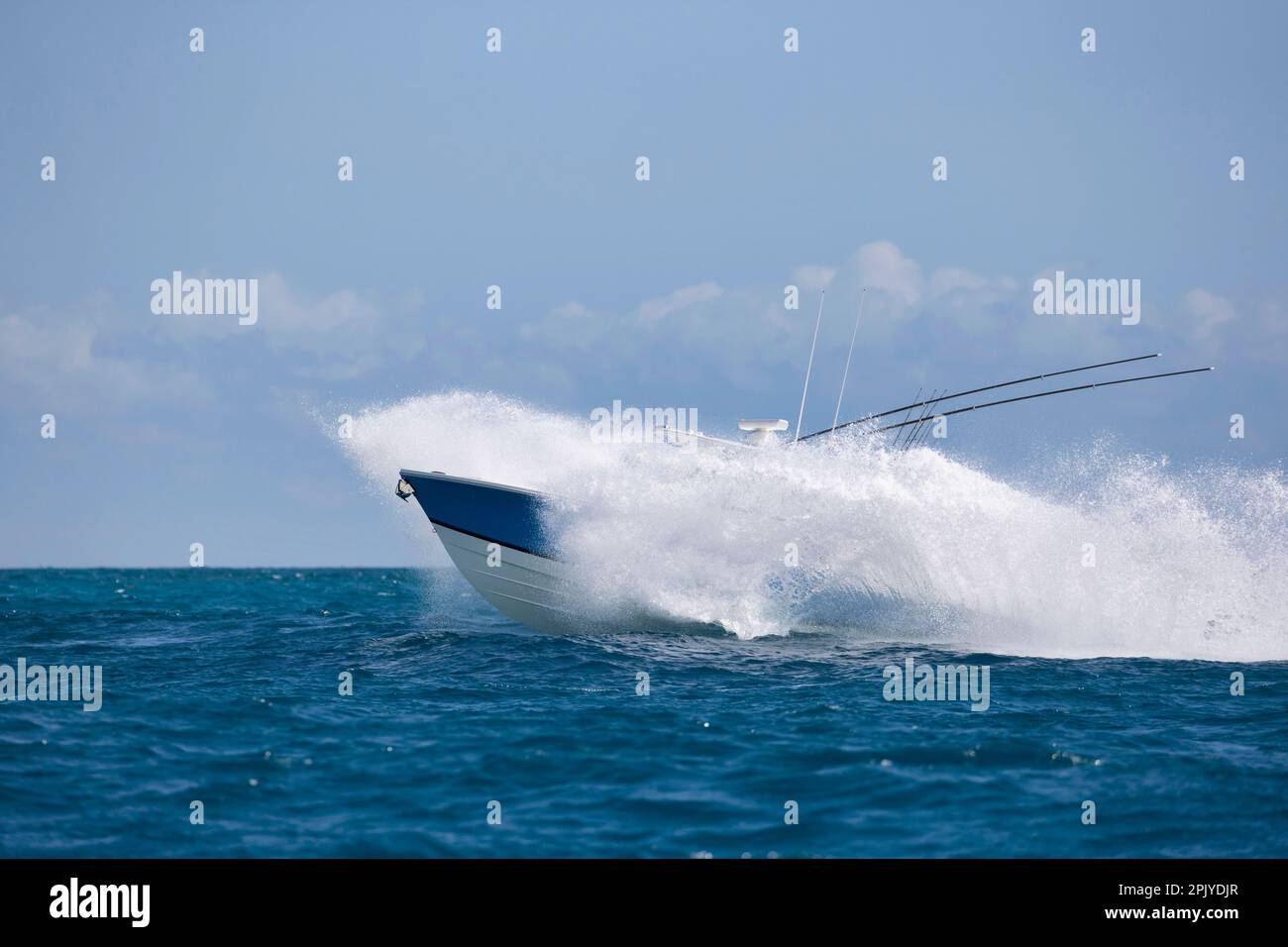 Un motoscafo veloce quasi nascosto da spruzzi nell'oceano. Foto Stock