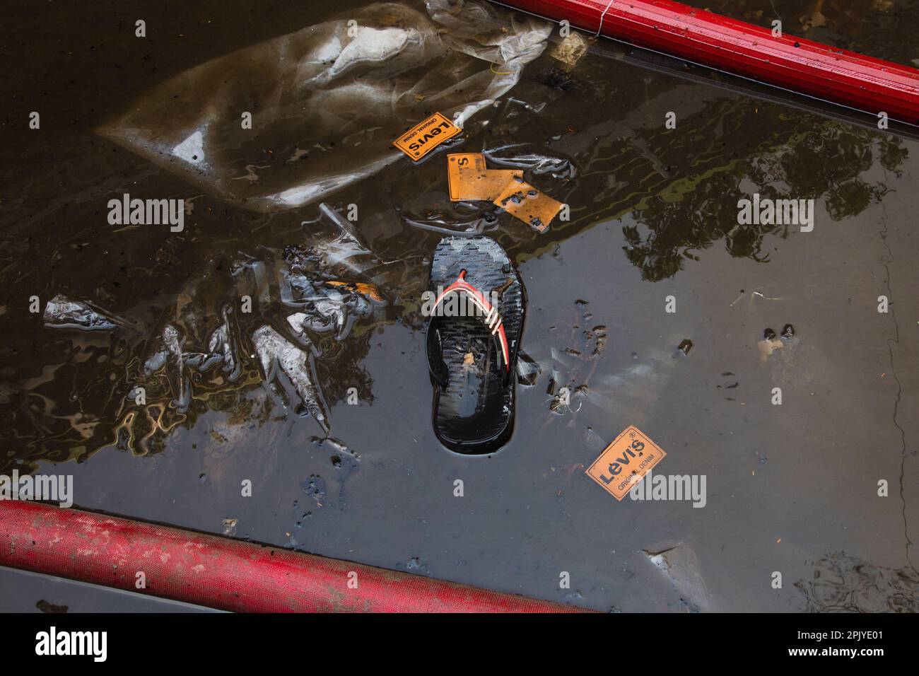 Un marchio popolare logo tag è visto galleggiare accanto a un tubo di acqua di servizio antincendio come un fuoco massiccio scoppiato in un mercato di abbigliamento a Dhaka, Bangladesh il 4 aprile 2023 (Foto di Nahid Hasan/Pacific Press) Credit: Pacific Press Media Production Corp./Alamy Live News Foto Stock