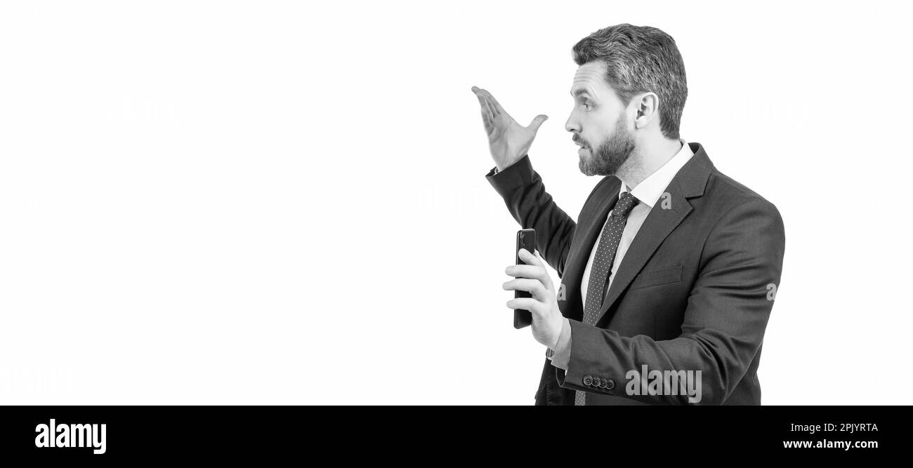 Non disturbarmi. Un uomo d'affari arrabbiato tiene lo smartphone. Chiamata aziendale. Chiamata su cellulare. Uomo volto ritratto, banner con spazio copia. Uomo d'affari in tuta, isolat Foto Stock