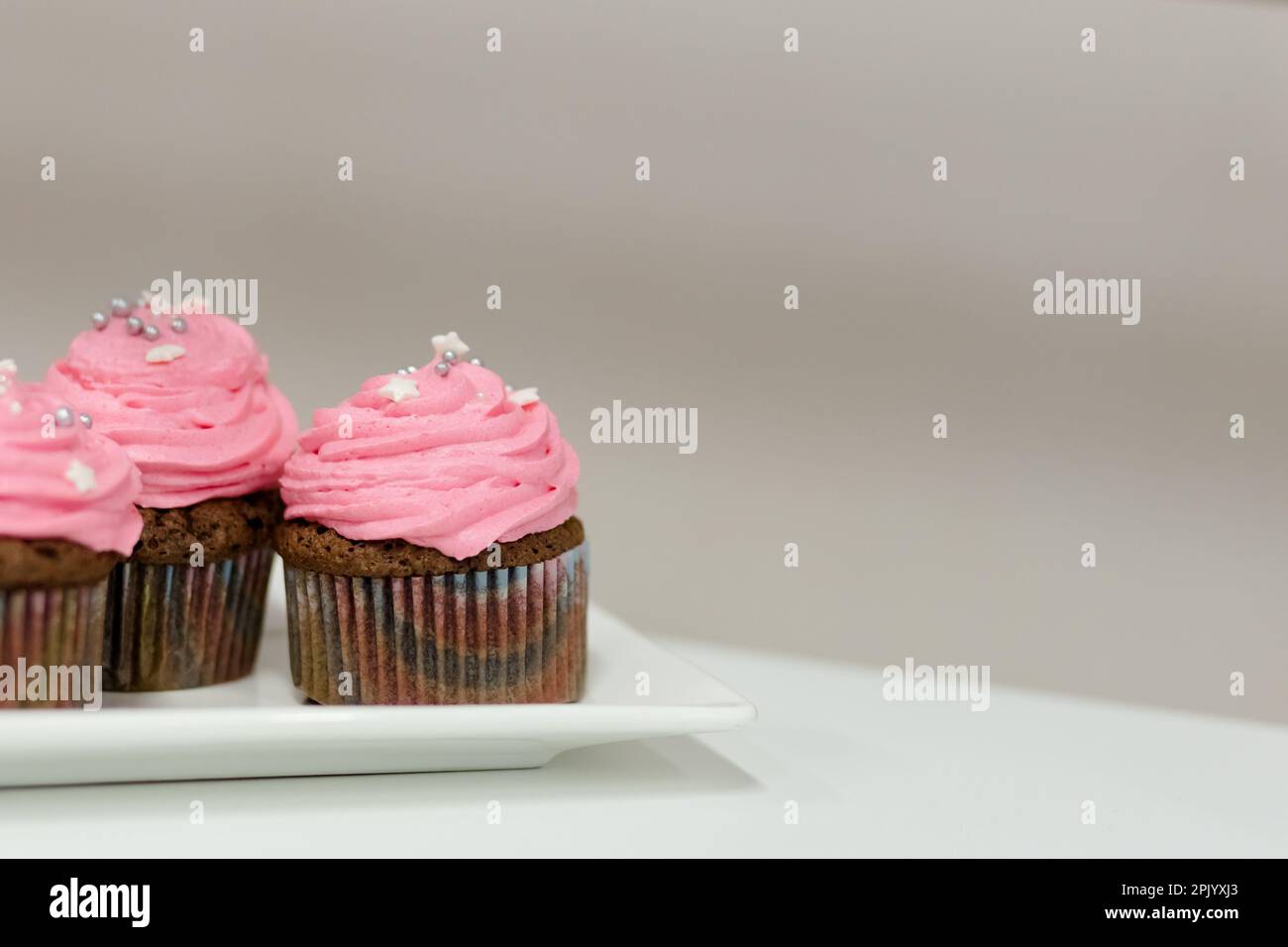 Tortini per le vacanze con crema rosa e ripieno di lamponi. Primo piano Foto Stock