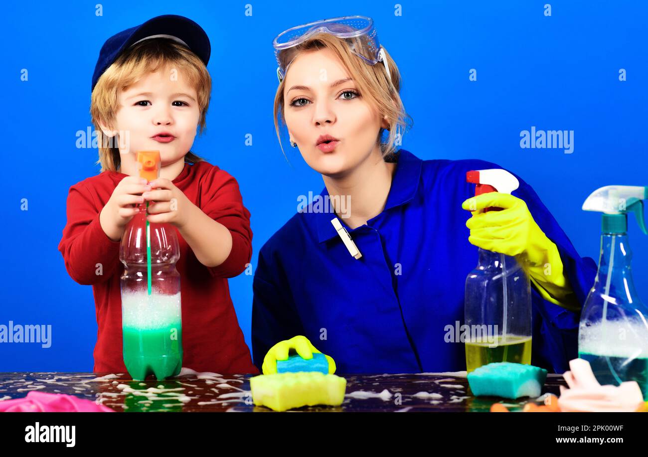 Bambino piccolo e mamma con prodotti per la pulizia. La famiglia felice pulisce la casa. Pulizia della molla. Lavori domestici di famiglia e famiglia. Carino piccolo aiutante. Figlio Foto Stock