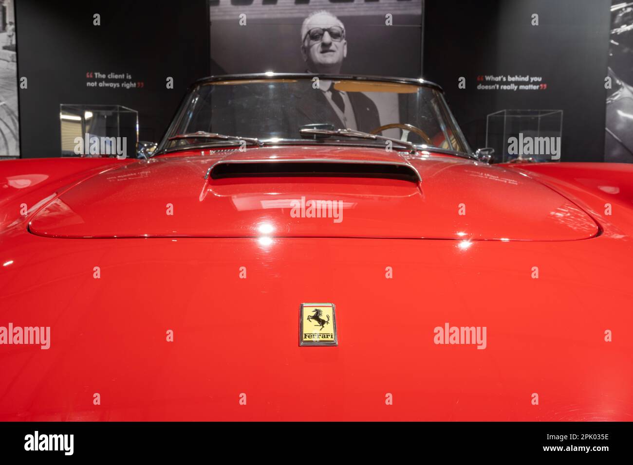 Sparkford.Somerset.United Kingdom.March 26th 2023.A 1960 Ferrari 250 GT cabriolet è in mostra davanti ad un ritratto di Enzo Ferrari al Haynes Moto Foto Stock