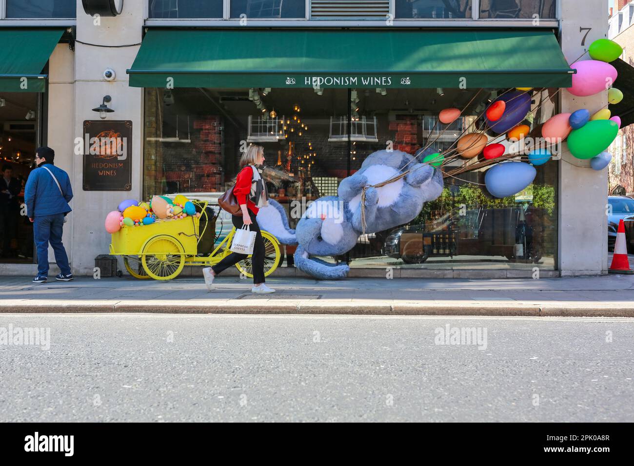 Londra, Regno Unito. 04 Apr 2023. La gente passa davanti a un coniglietto di Pasqua gigante e uova fuori Hedonism negozio di vini a Mayfair - decorazione di Pasqua. © Waldemar Sikora Foto Stock