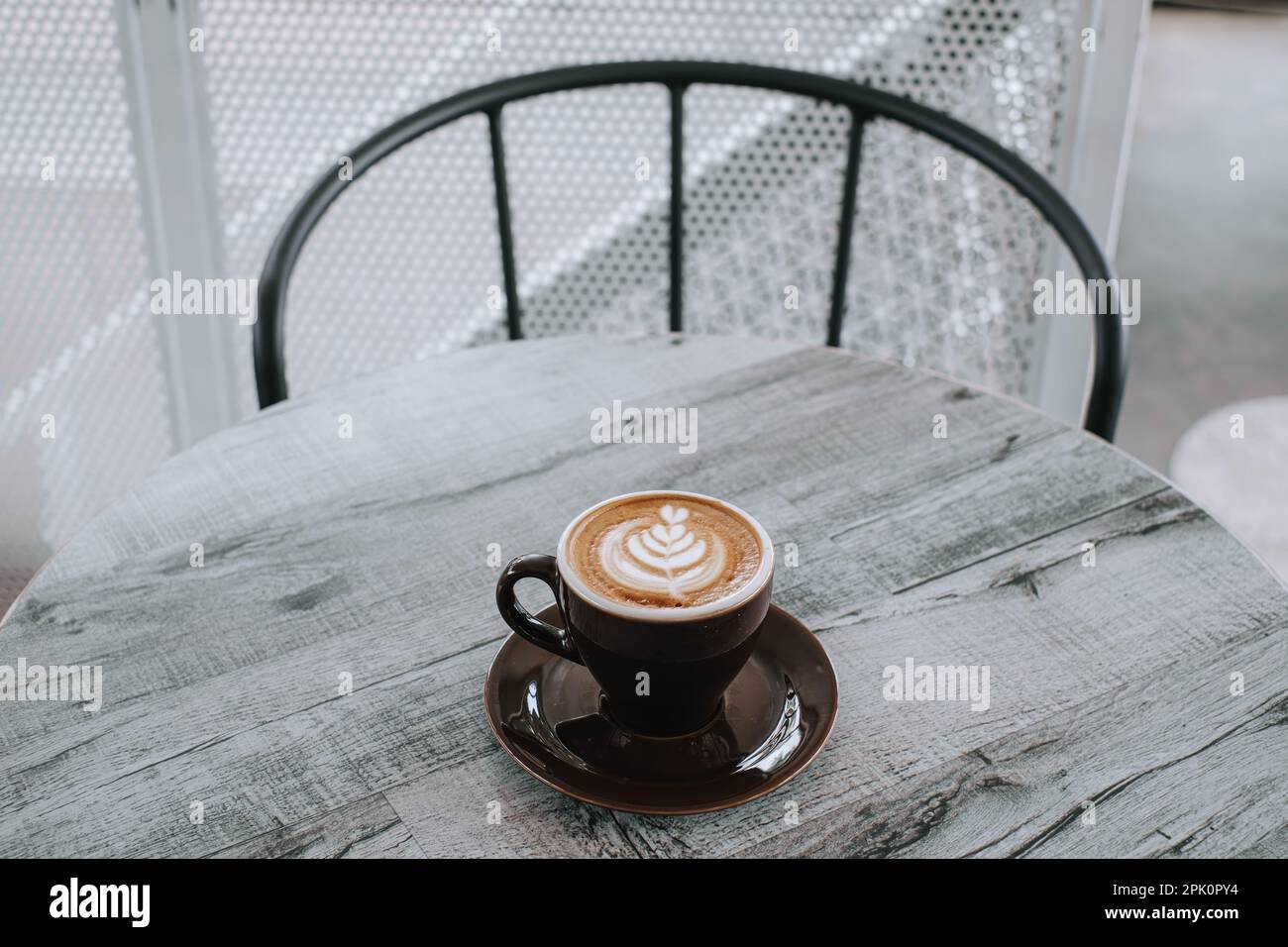 Una tazza di caffè con latte art su un tavolo di legno. Sfondo sfocato. Foto Stock