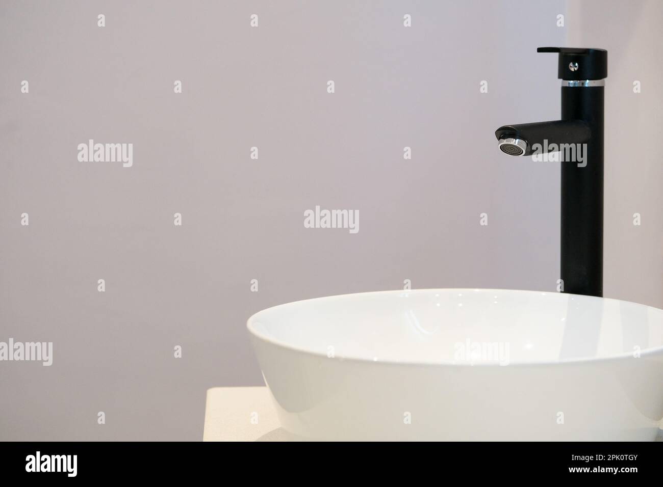 Primo piano rubinetto e lavabo interno bagno con parete vuota. Messa a fuoco selettiva dell'area. Spazio aperto per la scrittura. Foto Stock