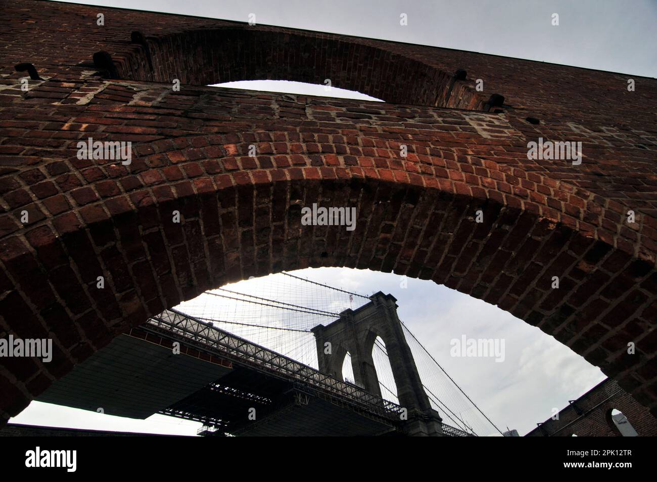 Il Ponte di Brooklyn, visibile attraverso una finestra del vecchio magazzino di tabacco in Fulton Landing State Park, New York City, Stati Uniti d'America Foto Stock