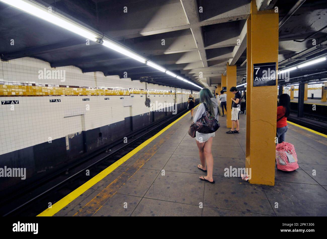 I passeggeri in attesa sul binario della stazione 7th Avenue a Manhattan, New York City. Foto Stock