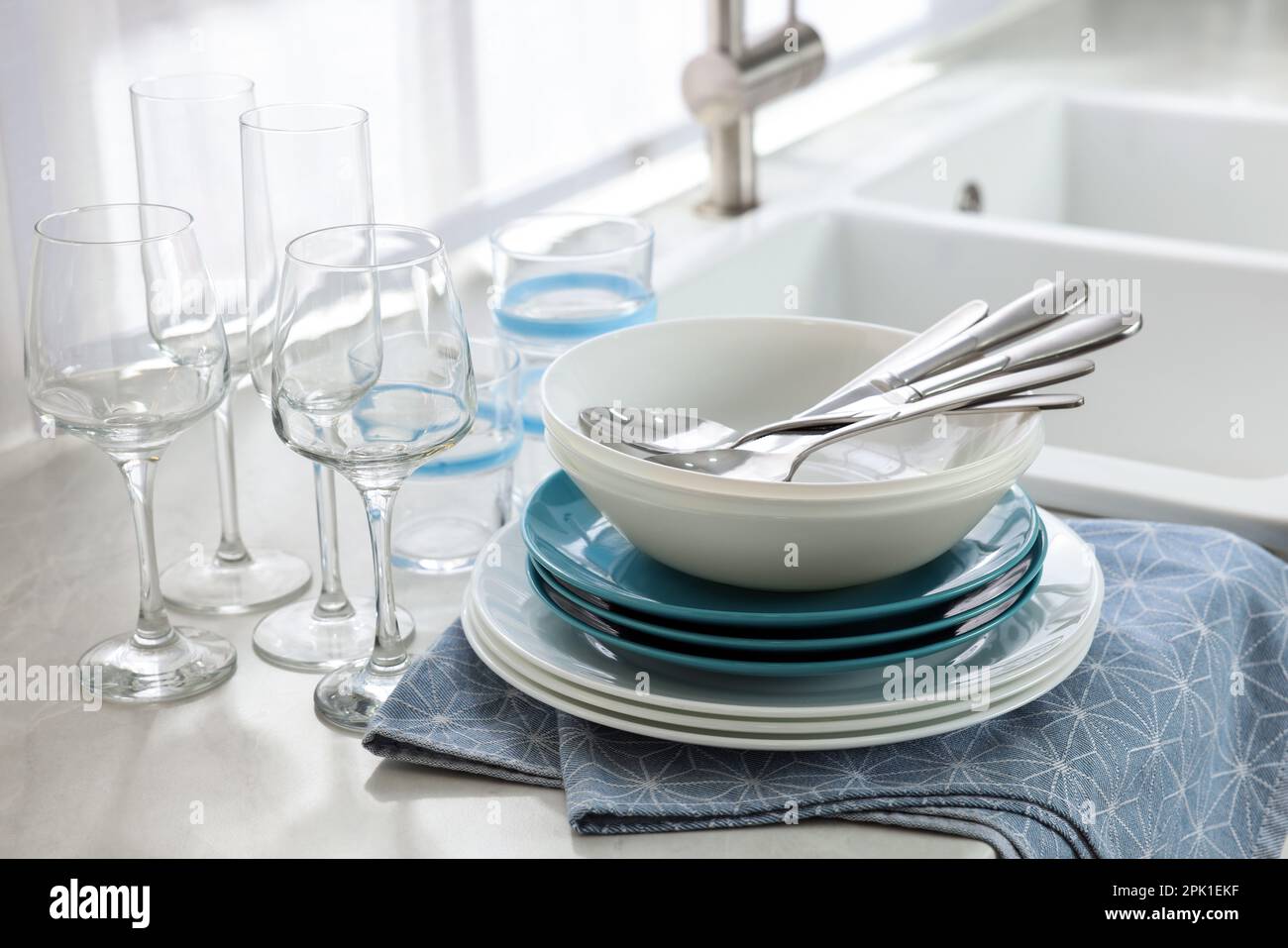 Diversi piatti, posate e bicchieri puliti sul piano di lavoro in cucina  Foto stock - Alamy