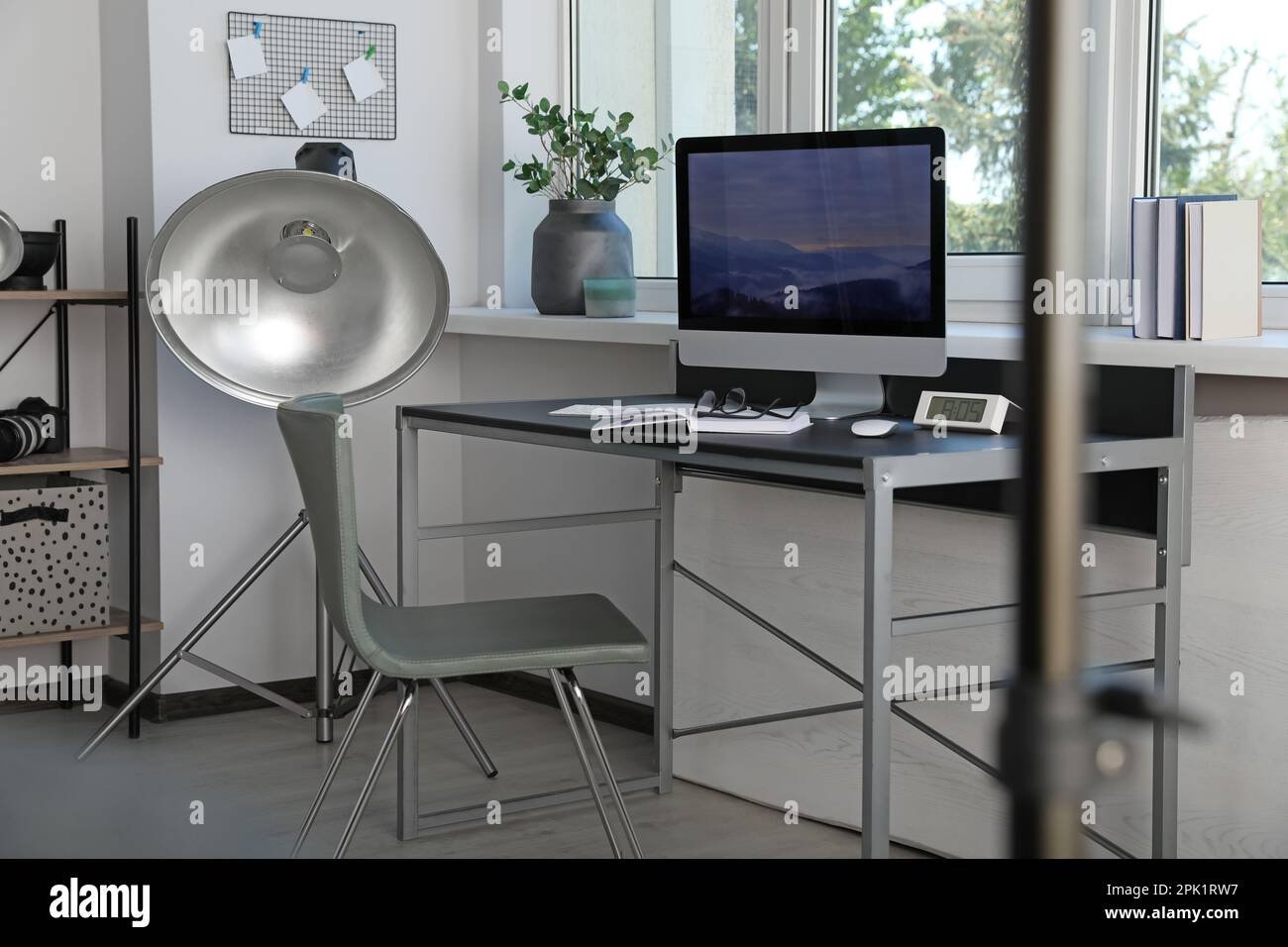 Apparecchiature di illuminazione professionali e comodo posto di lavoro in studio fotografico. Design degli interni Foto Stock