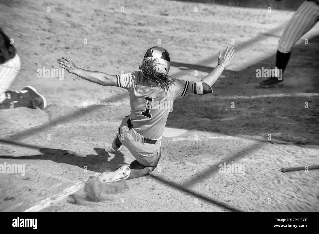 Un giocatore di softball femminile sta scivolando nel piatto principale Foto Stock