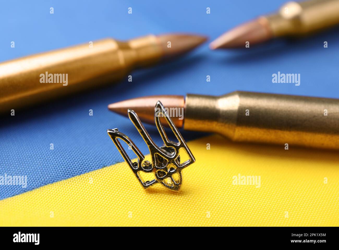 Tridente ucraino e proiettili sulla bandiera nazionale dell'Ucraina, primo piano Foto Stock