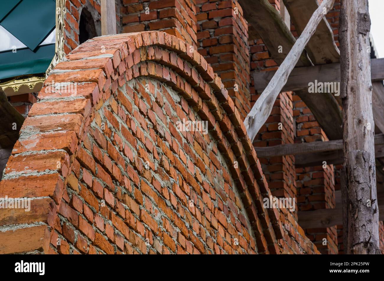costruzione di un campanile e di una chiesa. Muro di mattoni. Ponteggi in legno Foto Stock
