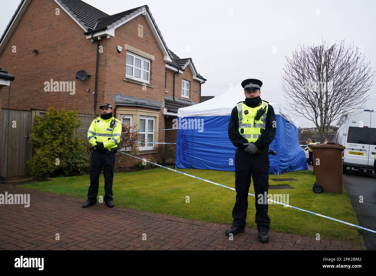 Gli ufficiali della polizia scozzese si trovano accanto a un nastro di polizia e a una tenda di polizia fuori dalla casa dell'ex amministratore delegato del Partito nazionale scozzese (SNP) Peter Murrell, a Uddingston, Glasgow, dopo essere stato arrestato in relazione alle indagini in corso sul finanziamento e le finanze del partito. Data immagine: Mercoledì 5 aprile 2023. Foto Stock