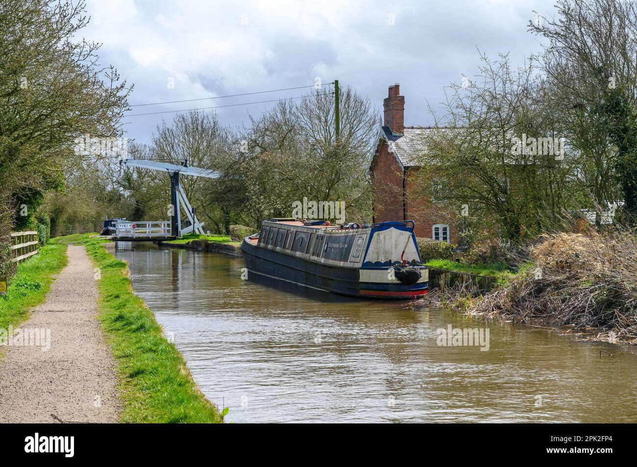 Narrowboat ormeggiato accanto a un cottage sul lato del canale adiacente al ponte di Allman sul ramo delle prete del canale di Llangollen Foto Stock