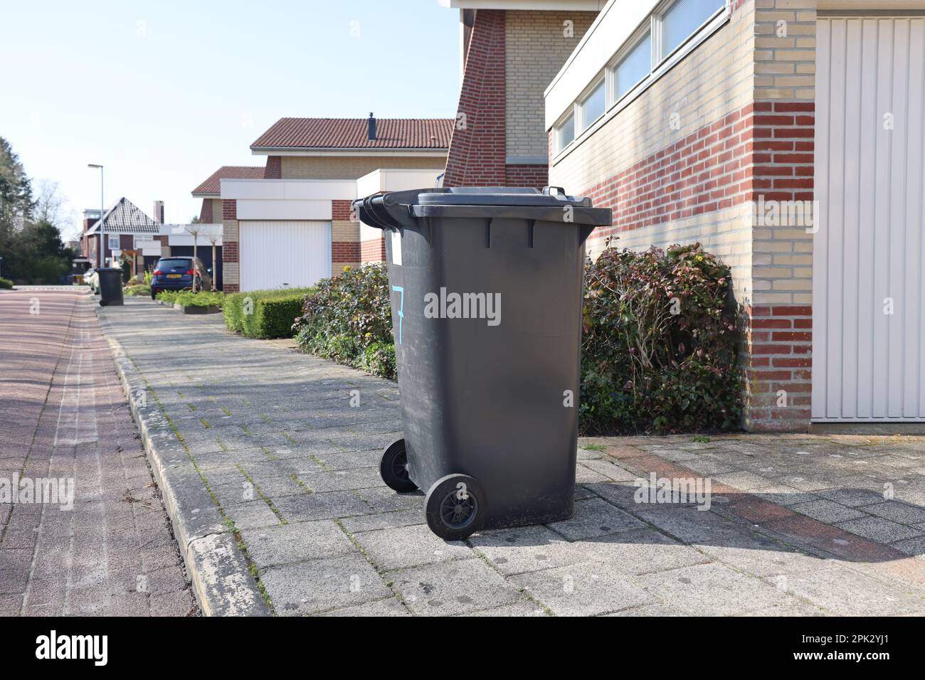 Contenitori per rifiuti in plastica, alias kliko's (o cassoni), all'esterno sul marciapiede in un'area residenziale Foto Stock