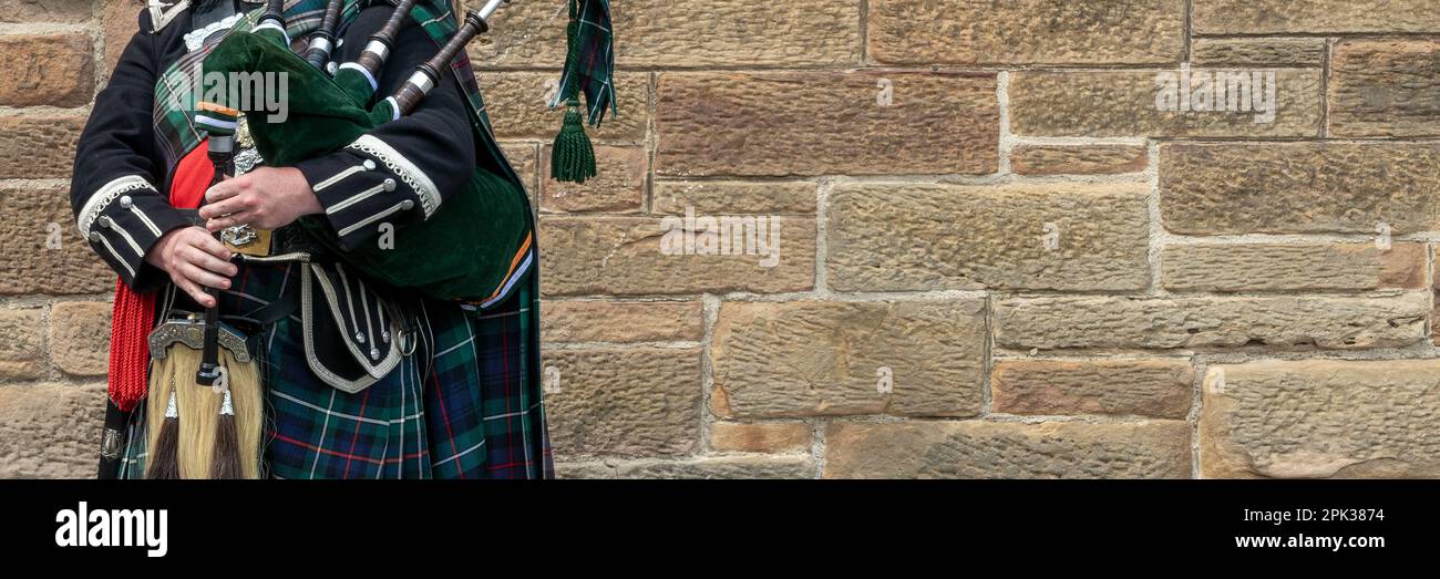 Bagpiper scozzese vestito in kilt tradizionale a Edimburgo, Scozia. Panorama con spazio di copia. Foto Stock