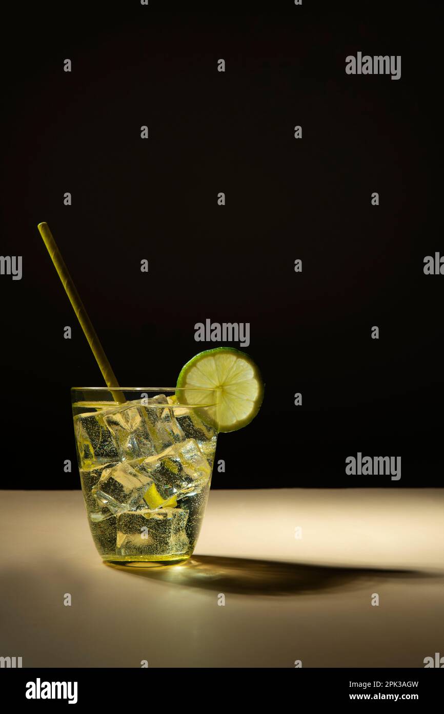 cocktail con limone su fondo scuro Foto Stock