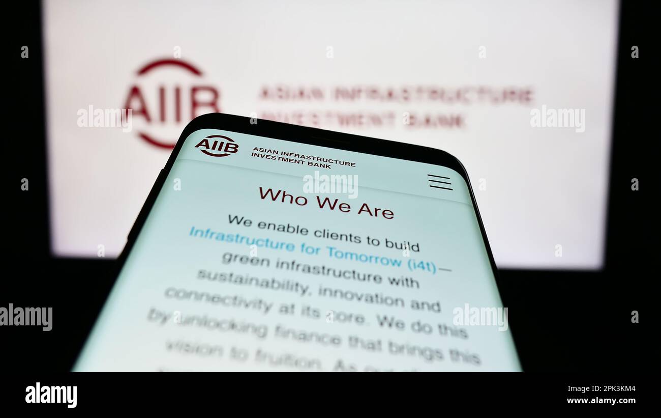 Telefono cellulare con sito Web della Banca asiatica d'investimento per le infrastrutture (AIIB) sullo schermo di fronte al logo aziendale. Messa a fuoco in alto a sinistra del display del telefono. Foto Stock