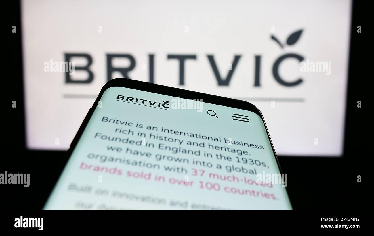 Telefono cellulare con pagina web della società britannica di bevande analcoliche Britvic plc sullo schermo di fronte al logo aziendale. Messa a fuoco in alto a sinistra del display del telefono. Foto Stock
