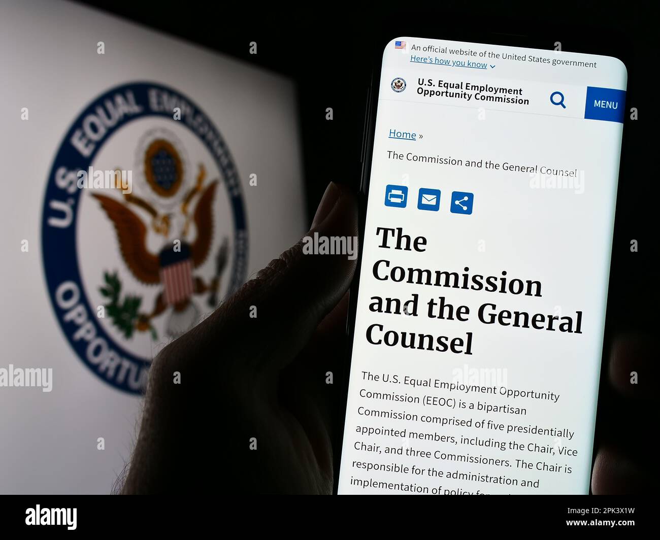 Persona che tiene il cellulare con pagina web della Commissione di pari opportunità di impiego (EOC) sullo schermo con il logo. Messa a fuoco al centro del display del telefono. Foto Stock