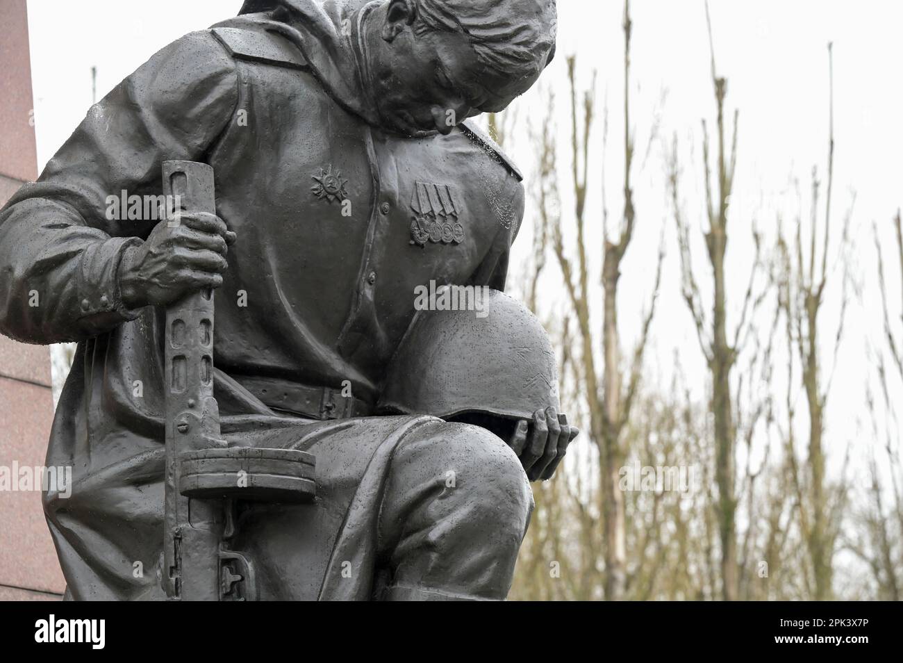 GERMANIA, ex Berlino Est, Treptow, memoriale sovietico della seconda guerra mondiale e cimitero dei soldati con 7000 tombe di soldati russi dell'Armata Rossa nel Parco Treptower, costruito nel 1946-49, soldato in ginocchio con pistola e statua dell'elmetto, culto dell'eroe Foto Stock