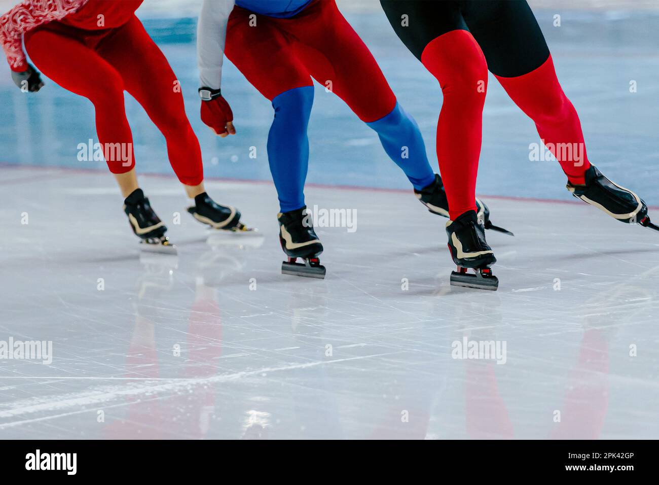 tre skater maschi corrono insieme gara di pattinaggio di velocità warm-up, giochi di sport invernali Foto Stock