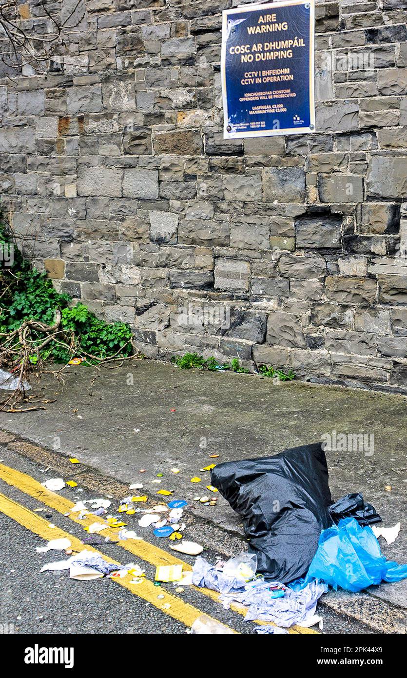 Sacco per rifiuti nero e altri rifiuti scaricati accanto a un cartello di divieto di dumping a Kilmainham, Dublino, Irlanda. Foto Stock