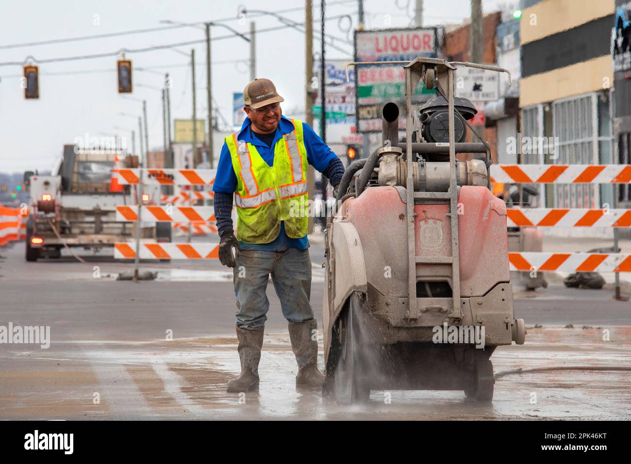 Detroit, Michigan - Un lavoratore gestisce una sega in cemento "walk-behind" come parte di un progetto per creare piste ciclabili protette, marciapiedi più ampi e per piantare tr Foto Stock