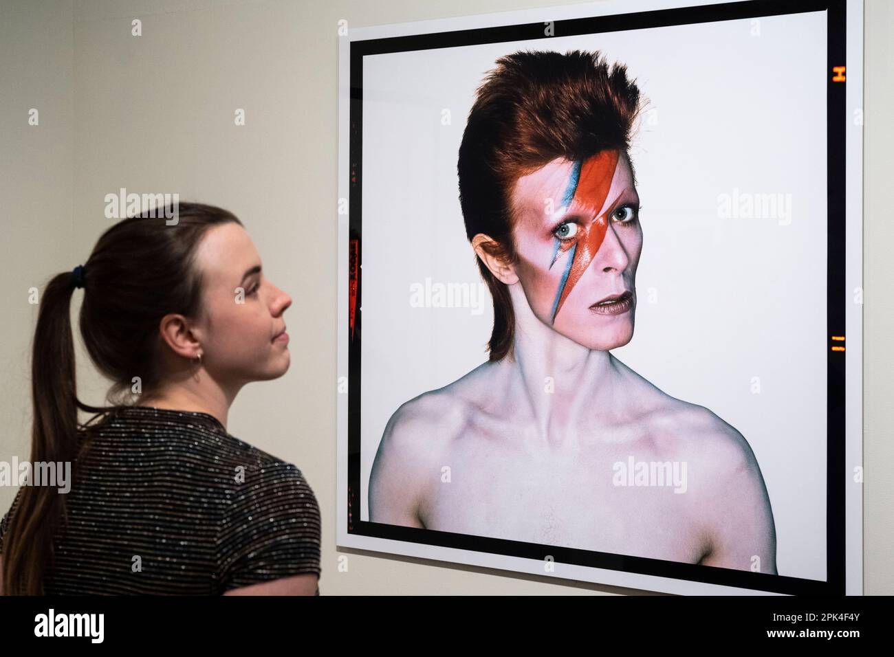 Londra, Regno Unito. 5 aprile 2023. Un membro dello staff vede 'Aladdin sane, girare a sinistra', 1973, di Brian Duffy, in anteprima di 'Aladdin sane: 50 anni', una nuova mostra al Royal Festival Hall del Southbank Centre. Cinquant’anni dopo l’uscita dell’album ‘Aladdin sane’ di David Bowie, la mostra esplora l’iconico ritratto di copertina ‘Lightning Bolt’ di Brian Duffy e la continua ridefinizione dell’immagine di Bowie. Lo spettacolo si svolge dal 6 aprile al 28 maggio. Credit: Stephen Chung / Alamy Live News Foto Stock