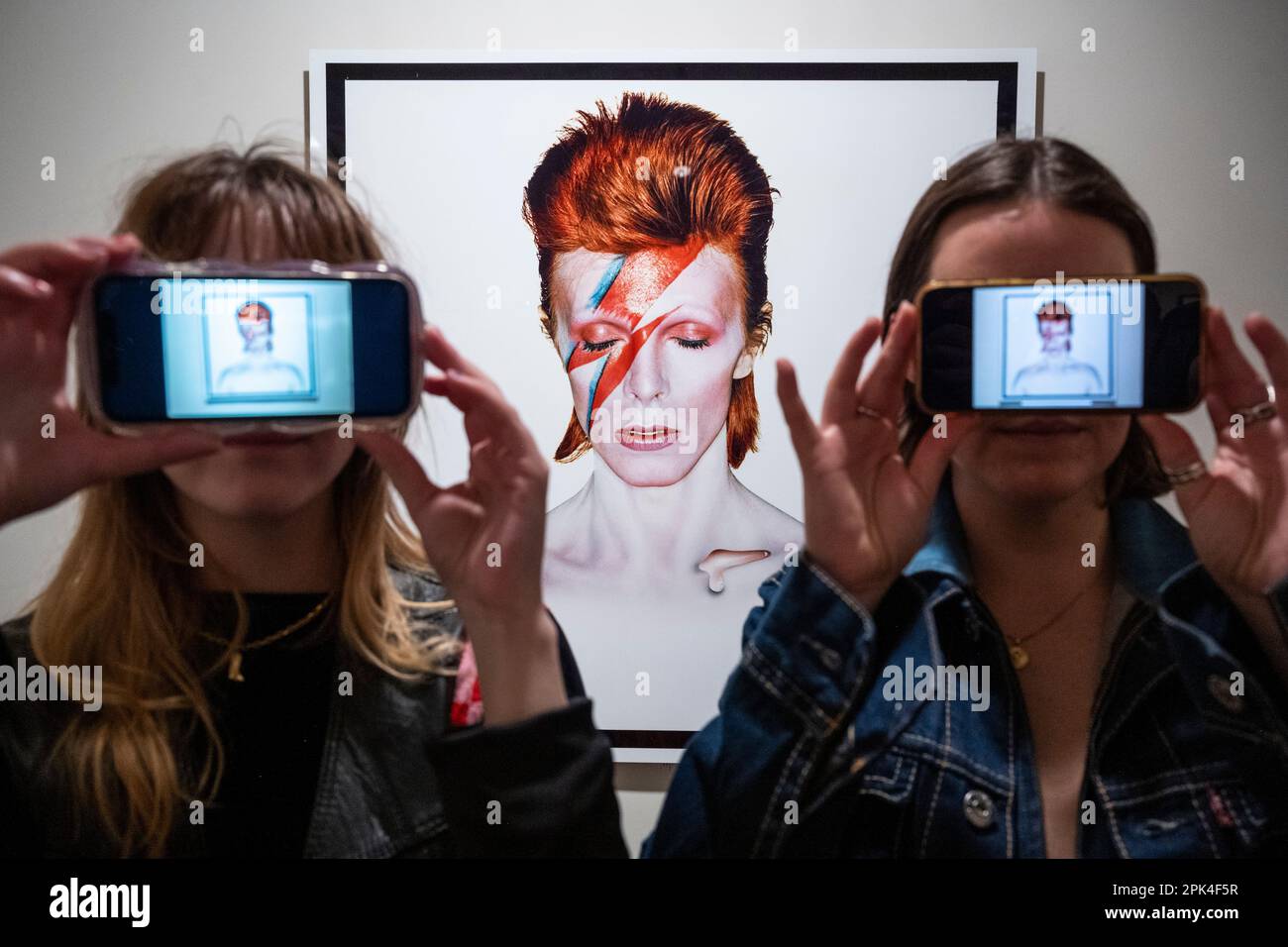 Londra, Regno Unito. 5 aprile 2023. I visitatori posano con i loro smartphone accanto a 'Aladdin sane, Eyes Shut', 1973, di Brian Duffy, in anteprima di 'Aladdin sane: 50 years', una nuova mostra al Royal Festival Hall del Southbank Centre. Cinquant’anni dopo l’uscita dell’album ‘Aladdin sane’ di David Bowie, la mostra esplora l’iconico ritratto di copertina ‘Lightning Bolt’ di Brian Duffy e la continua ridefinizione dell’immagine di Bowie. Lo spettacolo si svolge dal 6 aprile al 28 maggio. Credit: Stephen Chung / Alamy Live News Foto Stock