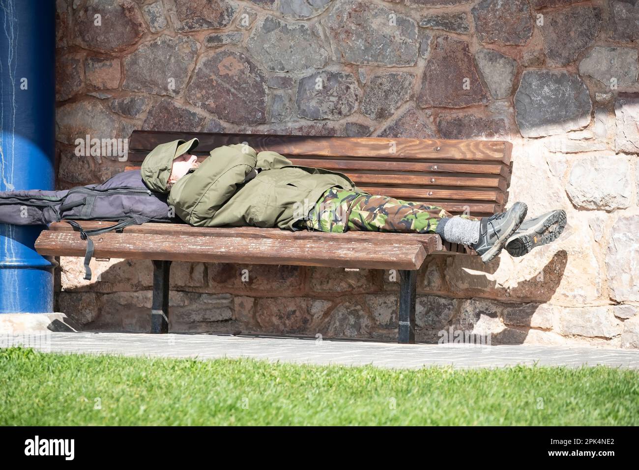 Un escursionista che si riposa su una panchina di mare in un rifugio in pietra sulla costa occidentale ai piedi del promontorio di Great Orme a Llandudno, Galles del Nord. Foto Stock