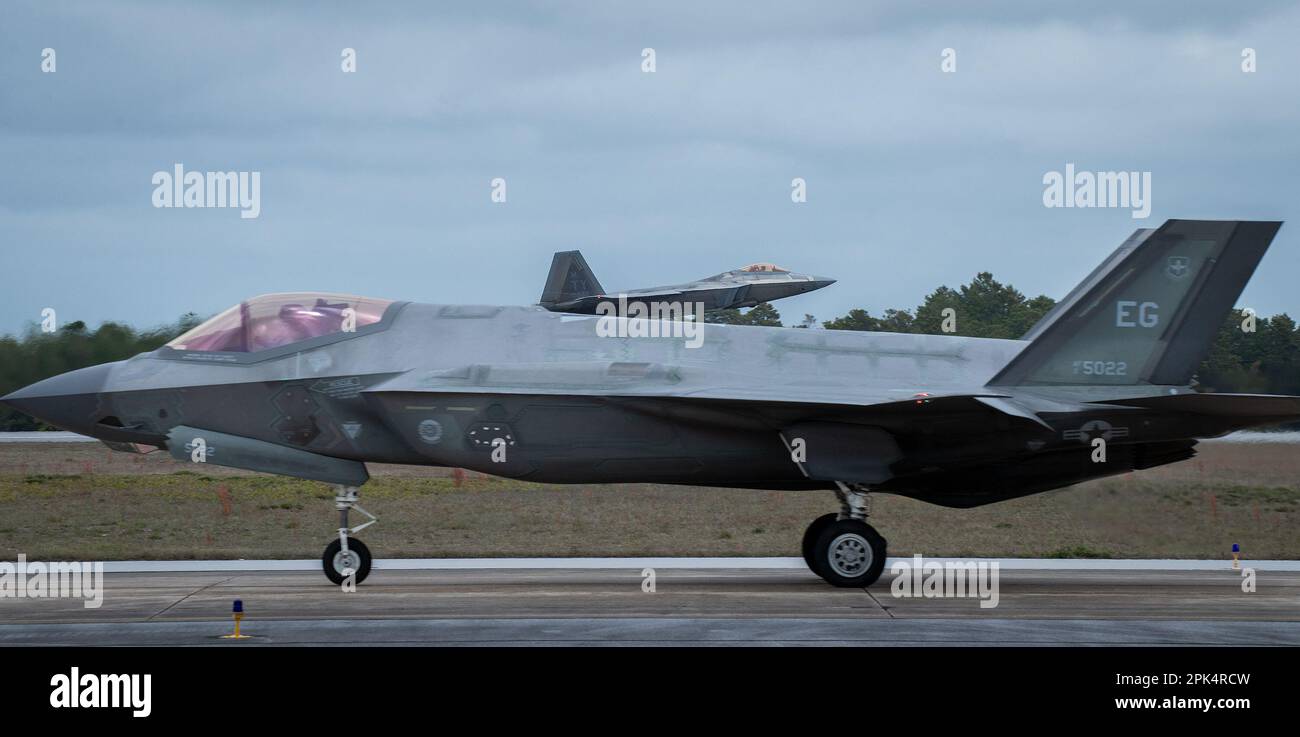 A 325th Fighter Wing F-22A Raptor vola da una 33rd Fighter Wing F-35A Lightning II Marzo 24 alla base dell'aeronautica militare di Eglin, Flah. Il velivolo Raptor del 325th FW si trova a Eglin dal 2018 dopo che l’uragano Michael ha distrutto le strutture della Tyndall AFB. I Raptors partiranno presto da Eglin per la loro nuova casa, Joint base Langley-Eustis, Virginia. (STATI UNITI Foto dell'aeronautica/Samuel King Jr.) Foto Stock