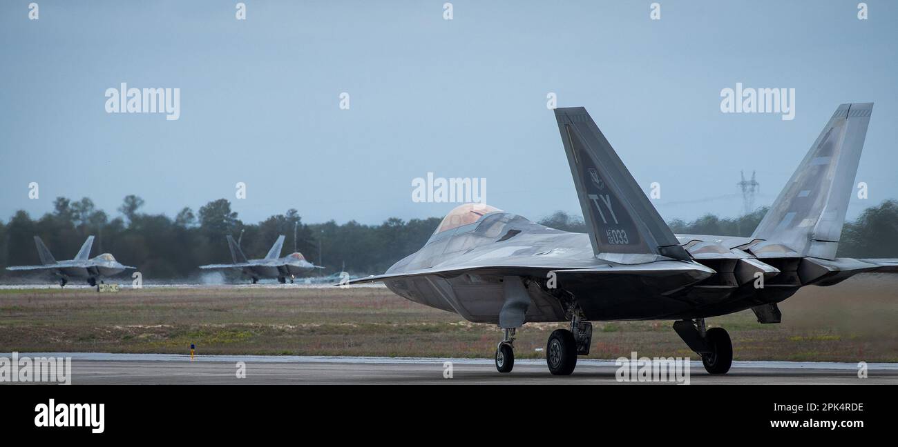 A 325th Fighter Wing F-22A Raptor taxi indietro dopo una missione come altri due si preparano a decollare il 24 marzo alla base dell'aeronautica Eglin, Flah. Il velivolo Raptor del 325th FW si trova a Eglin dal 2018 dopo che l’uragano Michael ha distrutto le strutture della Tyndall AFB. I Raptors partiranno presto da Eglin per la loro nuova casa, Joint base Langley-Eustis, Virginia. (STATI UNITI Foto dell'aeronautica/Samuel King Jr.) Foto Stock