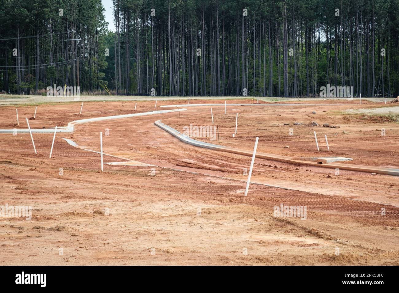 Cordoli di cemento in nuova suddivisione residenziale sono stati versati su terra di argilla rossa. Foto Stock
