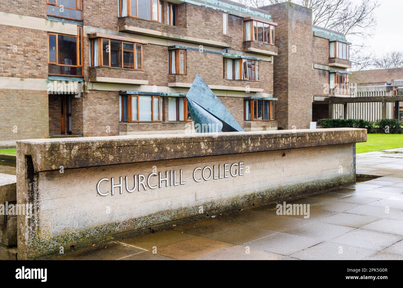 Il nome all'ingresso del Churchill College, parte dell'Università di Cambridge, Inghilterra orientale, visto da Storeys Way in una giornata di primavera bagnata Foto Stock