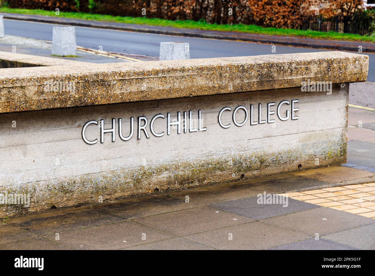 Il nome all'ingresso del Churchill College, parte dell'Università di Cambridge, Inghilterra orientale, visto da Storeys Way in una giornata di primavera bagnata Foto Stock