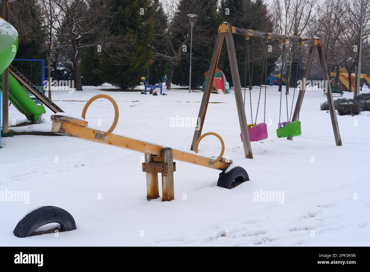 Parco giochi per bambini Teeter-Totter nel parco pubblico coperto di neve d'inverno Foto Stock