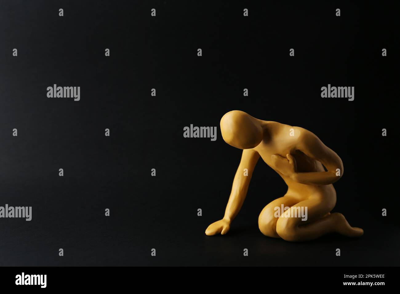 Plastilina figura di uomo che chiede aiuto su sfondo nero. Spazio per il testo Foto Stock