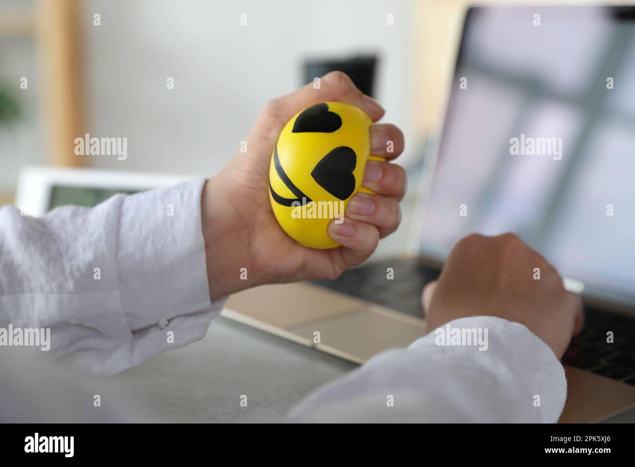 Uomo schiacciare palla antistress mentre lavora con il computer in ufficio,  primo piano Foto stock - Alamy