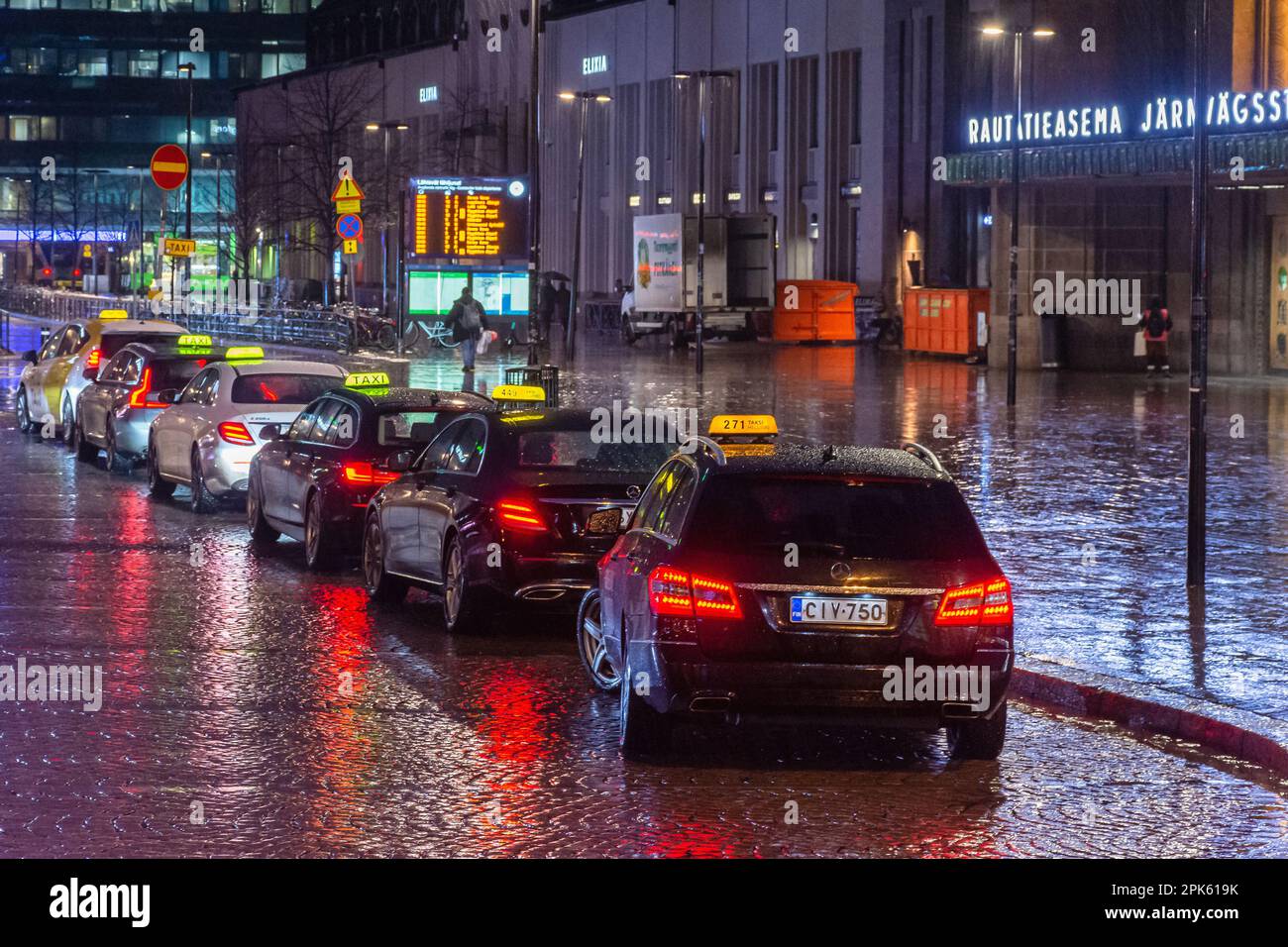 Taxi auto in attesa nella notte piovosa alla stazione ferroviaria di Helsinki Finlandia Foto Stock