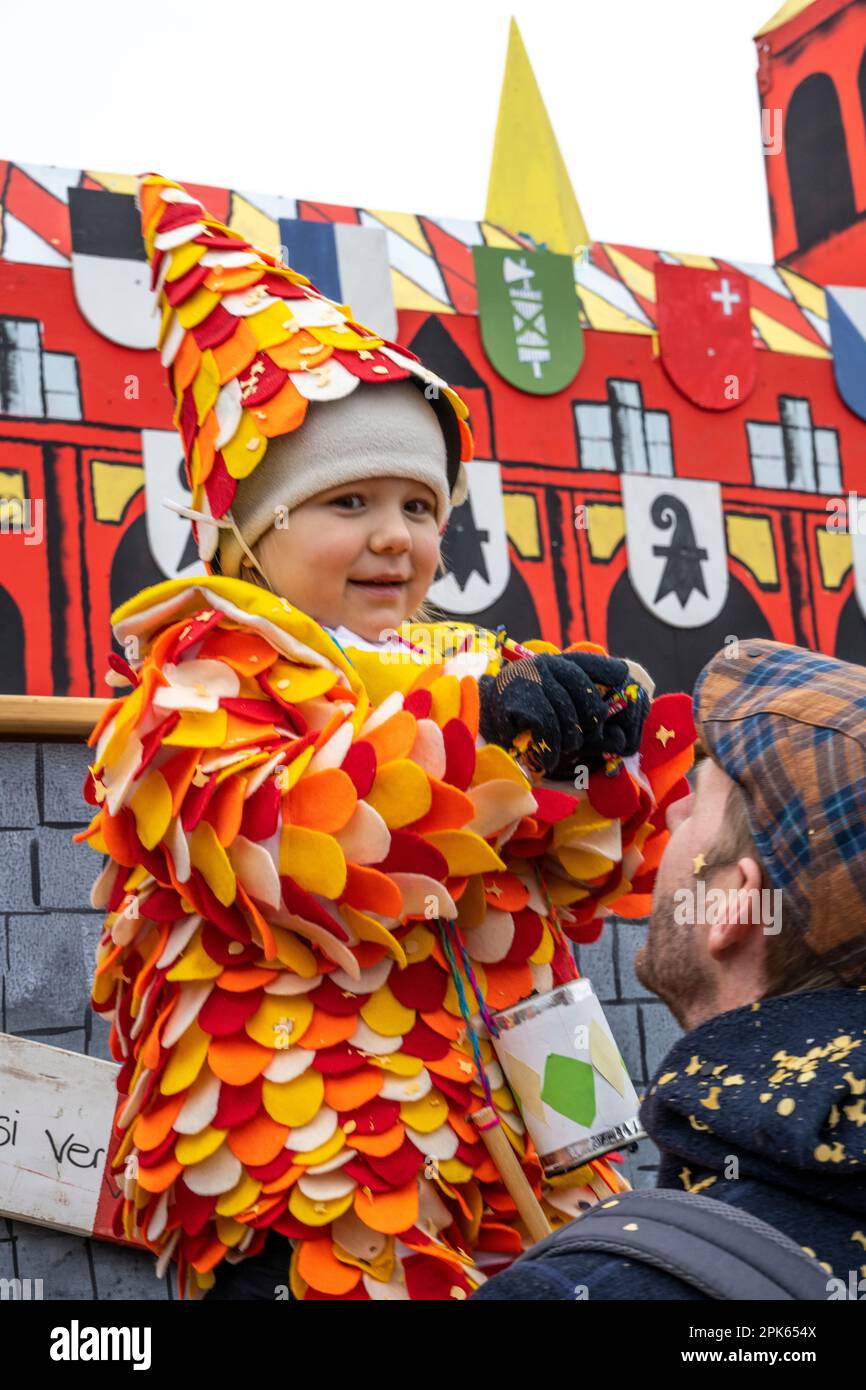 Giovane ragazza ad harlequin con costume e caramella alla parata di Basilea Fasnacht in Svizzera Foto Stock