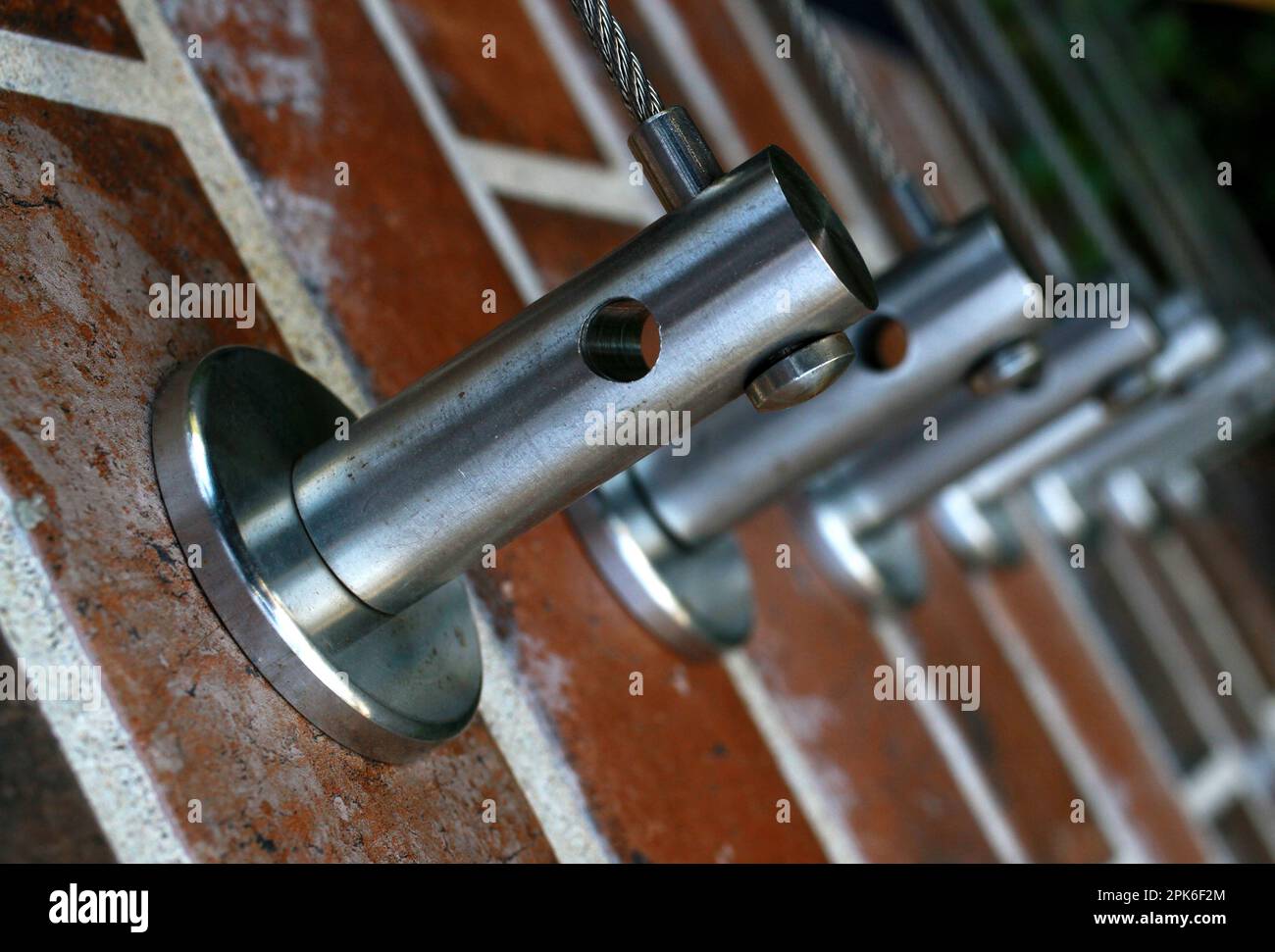 Fotografia di strada casuale di pali di metallo lucido per tenere filo sottile come una ringhiera, parti di costruzione fuori della città. Foto Stock
