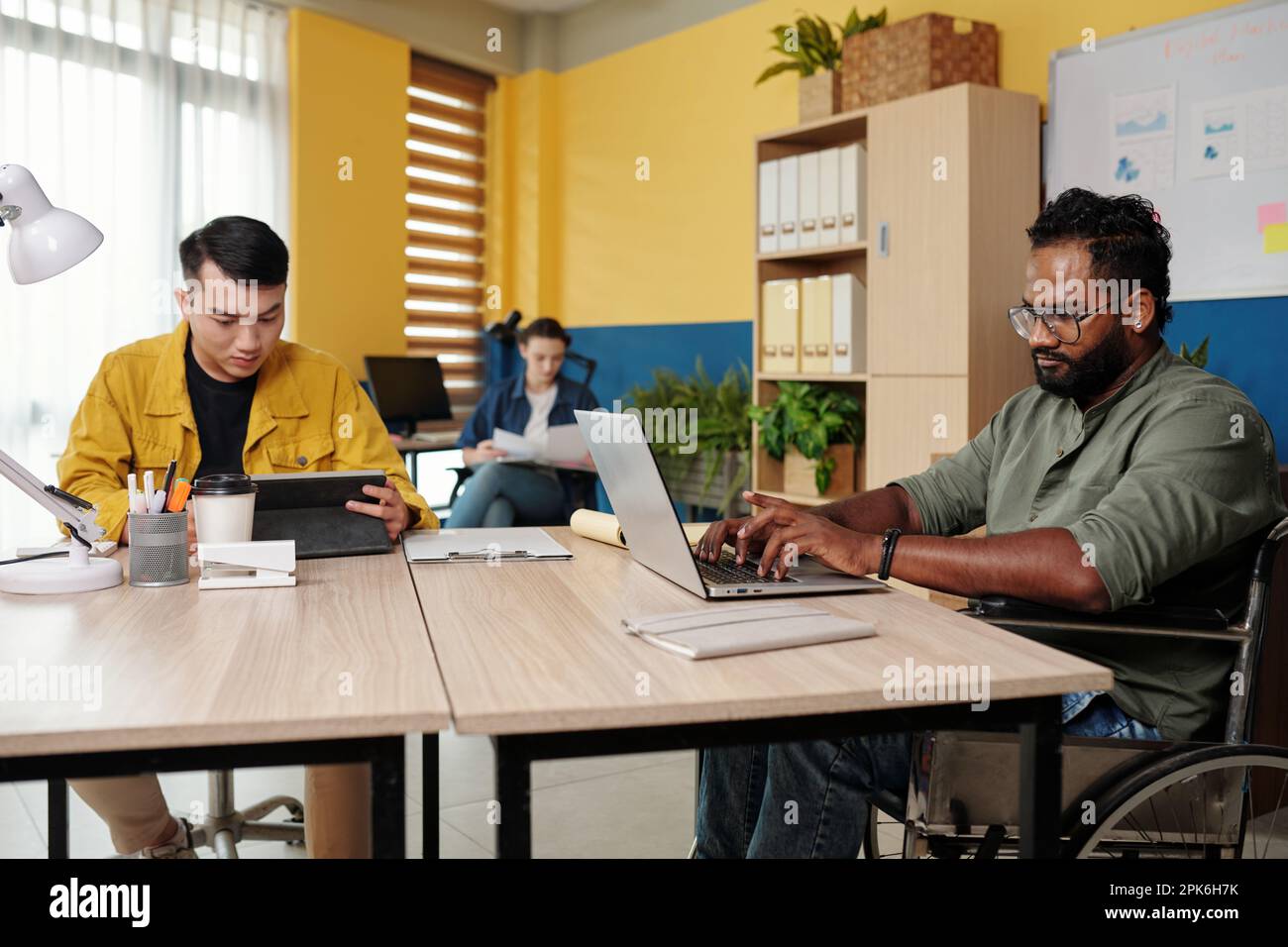 Team aziendale diversificato che lavora su grandi progetti in ufficio Foto Stock